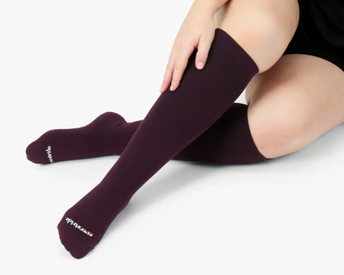 Woman wearing burgundy Everstride compression socks
